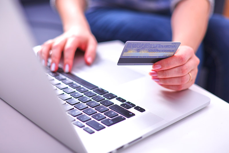 Person putting credit card numbers into laptop